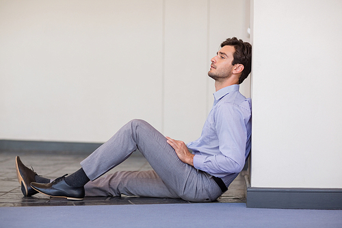 Worried businessman sitting on floor at conference centre