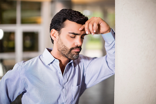 Worried and stressed businessman with hand on head at conference centre
