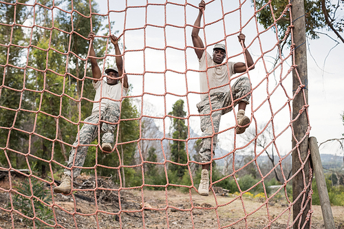 military soldiers climbing a net during obstacle course in 군사훈련