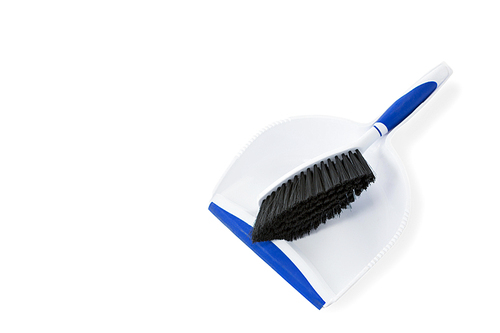 Close-up of broom and dustpan against white background