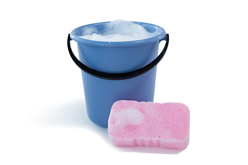 Cleaning sponge by bucket with soap sud against white background