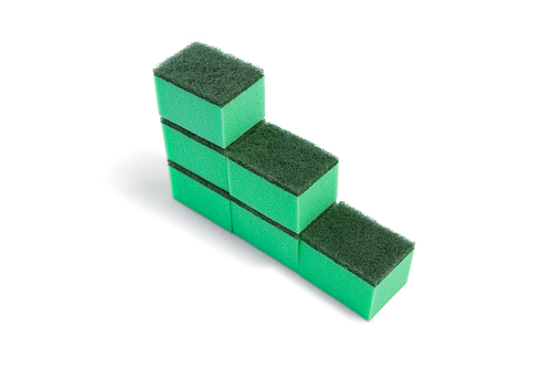 High angle view of cleaning sponge arranged in stack against white background