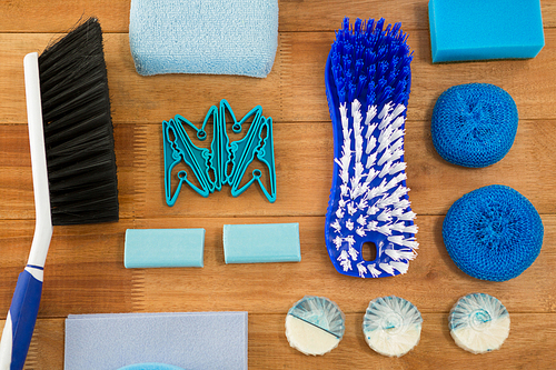 Overhead view of brushes and sponge with soaps on wooden table