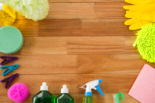 Overhead view of various cleaning products on wooden table
