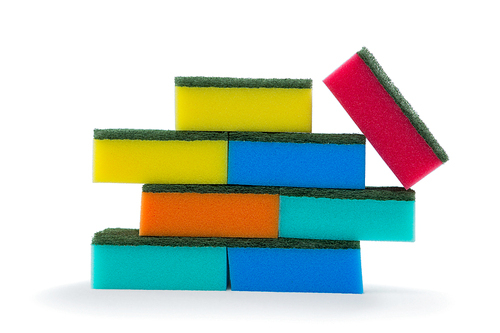 Close up of colorful sponges stacked against white background