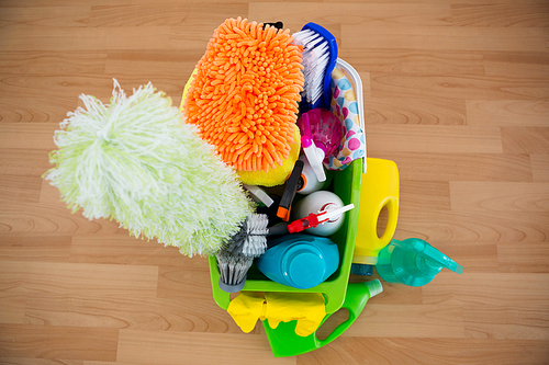 High angle view of duster and cleaning equipment in bucket on hardwood floor