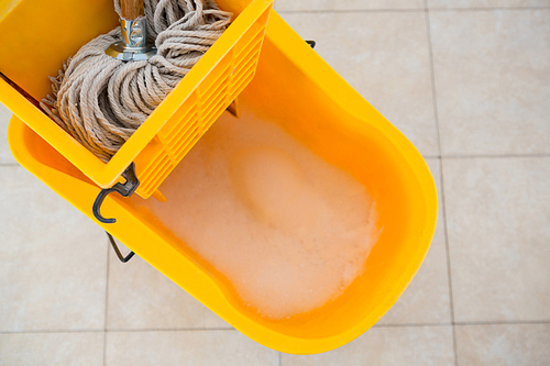 Overhead view of mop bucket on tiled floor