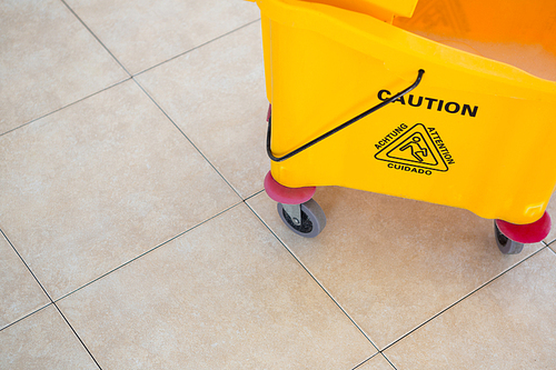 High angle view of sign on yellow mop bucket