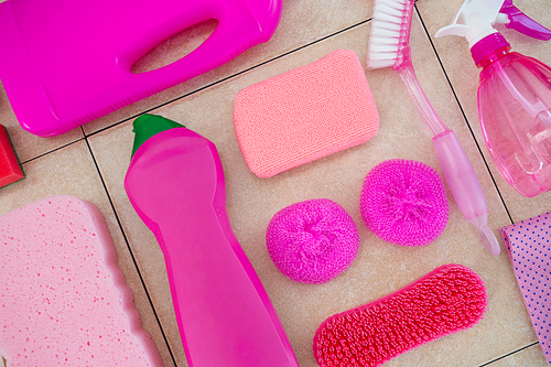 Close up of pink cleaning products on tiled floor