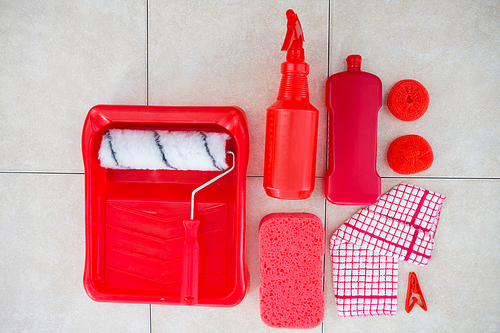 Overhead view of red cleaning products on tiled floor