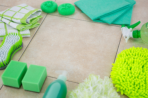 High angle view of green cleaning products arranged on tiled floor