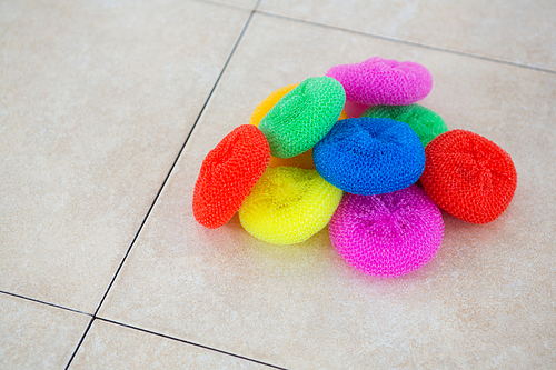 High angle view of colorful sponges on tiled floor