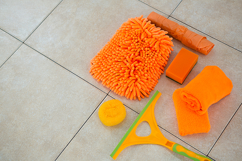 High angle view of orange cleaning products on tiled floor