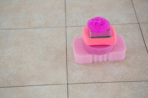 Close up of stacked sponges on tiled floor