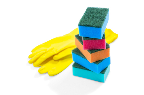 Close up of colorful sponges and gloves against white background
