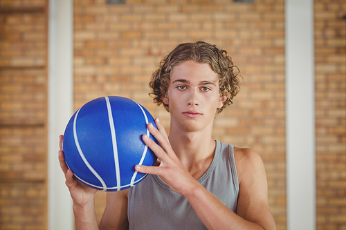 Determined boy holding a basketball in the court