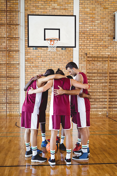 Basketball players forming a huddle in the court