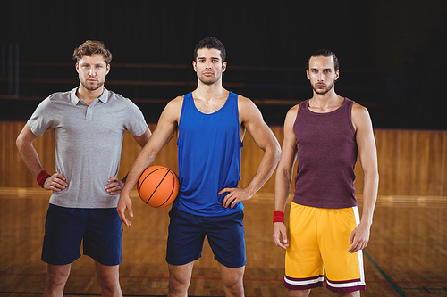 Portrait of male basketball players standing in basketball court