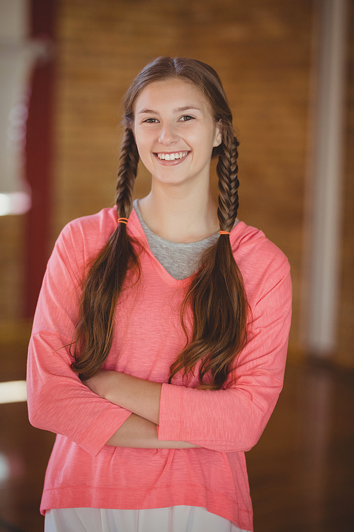Portrait of high school girl smiling while standing in basketball court