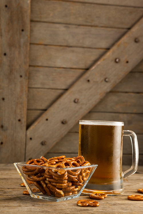 Close-up of st Patricks day mug of beer with pretzel on wooden surface