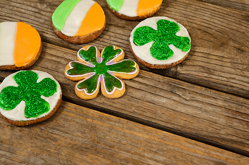 St. Patricks Day cookies decorated with irish flag and shamrock toppings on wooden background