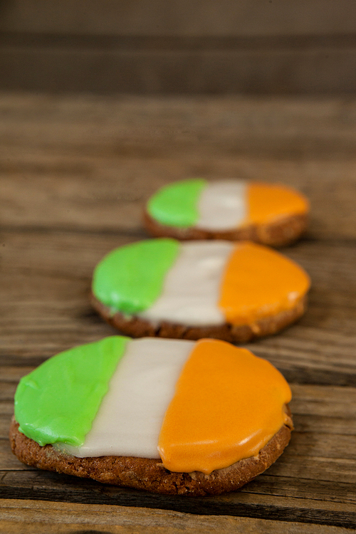 St. Patricks Day three cookies with irish flag toppings on wooden background