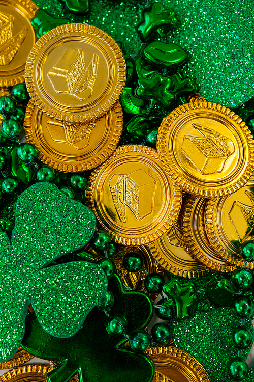 St. Patricks Day close-up of chocolate gold coins, beads and shamrocks