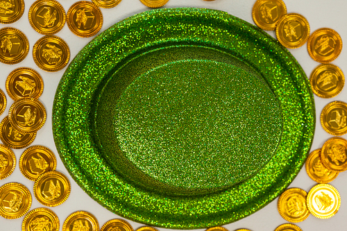 St Patricks Day leprechaun hat surround with gold chocolate coins on white background