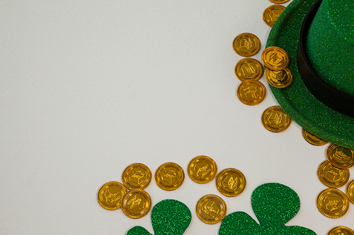 St. Patricks Day leprechaun hat, shamrocks and chocolate gold coins on white background