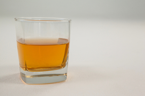 Close-up of glass of whisky on white background