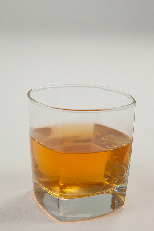 Close-up of glass of whisky on white background