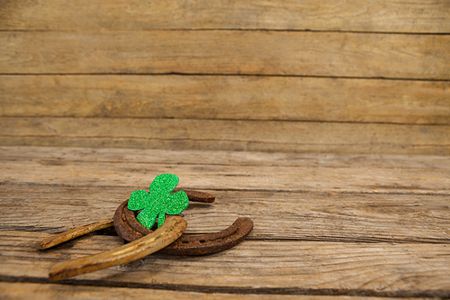 St Patricks Day shamrock with two horseshoes on wooden table