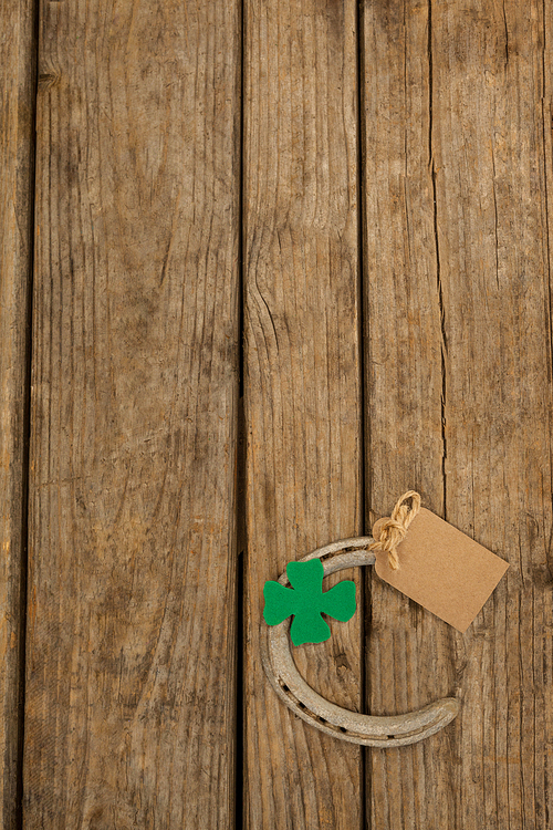 St Patricks Day horseshoe with empty tag and shamrock on wooden table