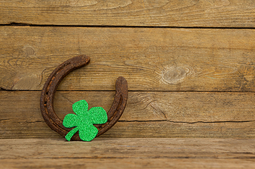 St Patricks Day shamrock with horseshoe on wooden surface