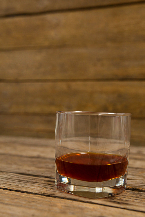 Close-up of glass of whisky on wooden table