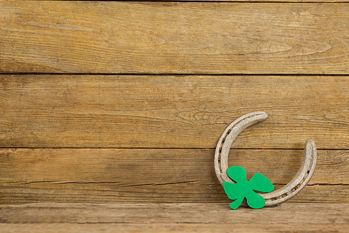 St Patricks Day shamrock with horseshoe on wooden surface