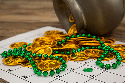St. Patricks Day close-up of chocolate gold coins and beads kept on calendar