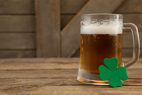 Glass of beer and shamrock for St Patricks Day on wooden table