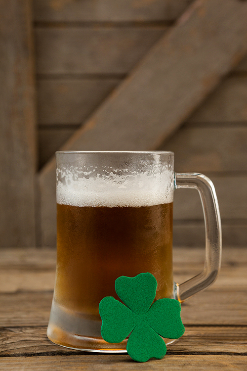 Glass of beer and shamrock for St Patricks Day on wooden table