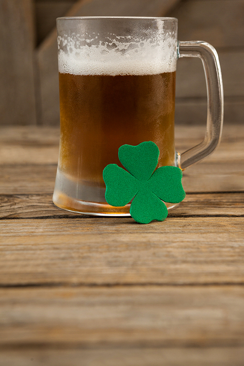 Glass of beer and shamrock for St Patricks Day on wooden table