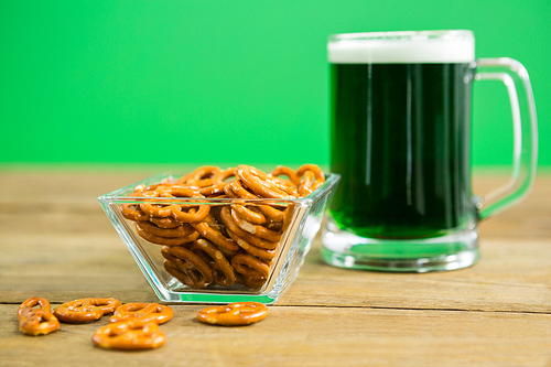 Close-up of st patricks day beer with pretzel on wooden surface