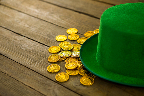 St Patricks Day leprechaun hat with gold chocolate gold coins??on wooden background