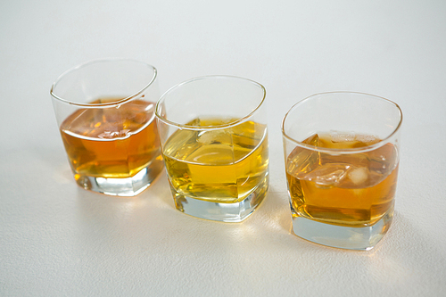 Three glasses of whiskey on white background
