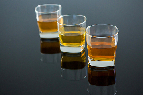 Three glasses of whiskey on table