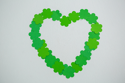St Patricks Day shamrocks forming heart shape on white background