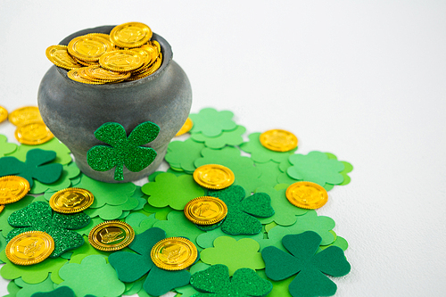 St. Patricks Day shamrock and pot filled with chocolate gold coins on white background
