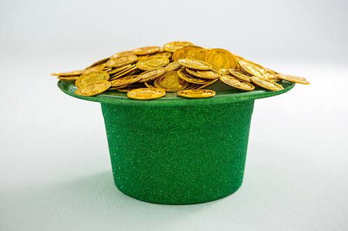 St. Patricks Day leprechaun hat filled with chocolate gold coins on white background