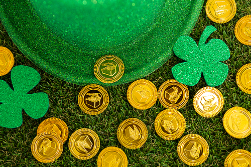 St. Patricks Day leprechaun hat, shamrocks and chocolate gold coins on grass