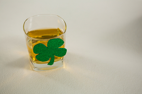 St Patricks Day glass of whisky with shamrock on grey background