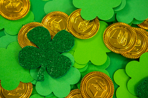 St Patricks Day shamrocks and gold chocolate coin on green background